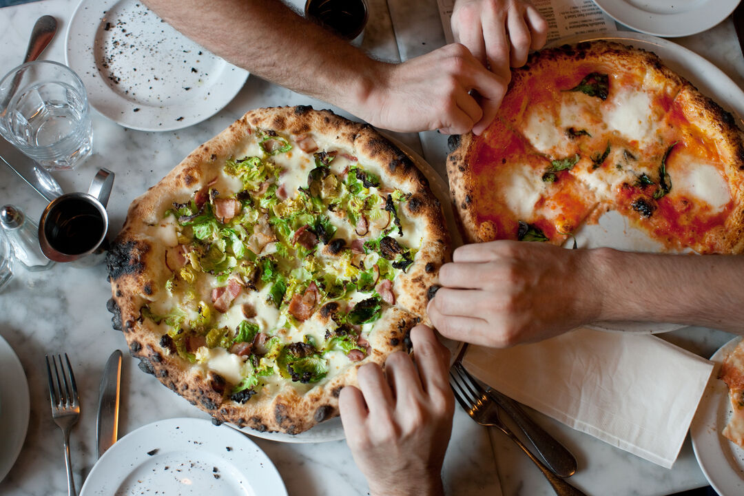 Hands Reach for Naples-Style Pizza